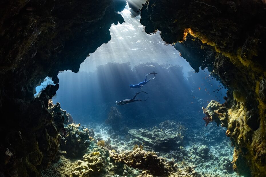 a scuba diver swims through an underwater cave